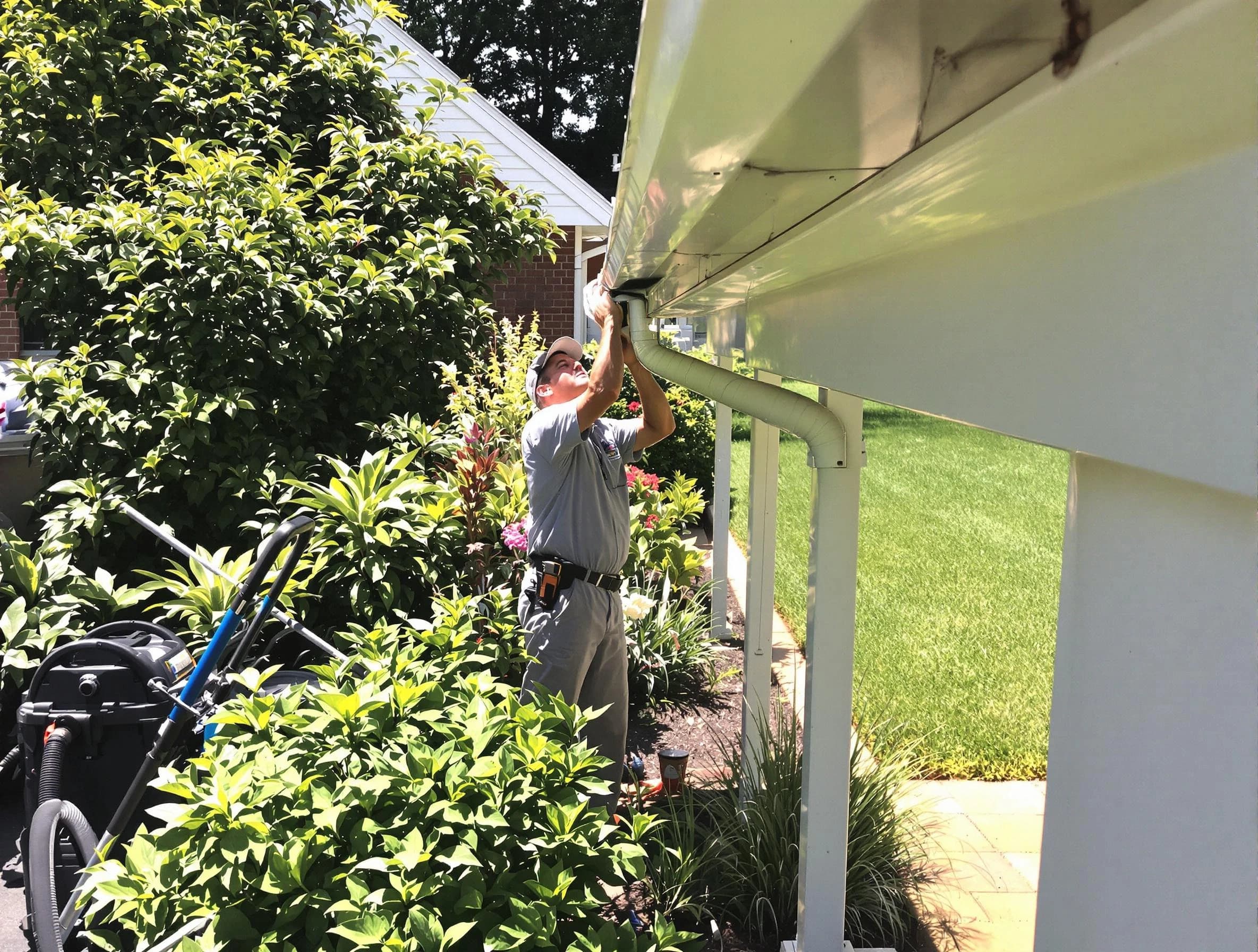 Technician flushing a blockage from a downspout in New Franklin, OH